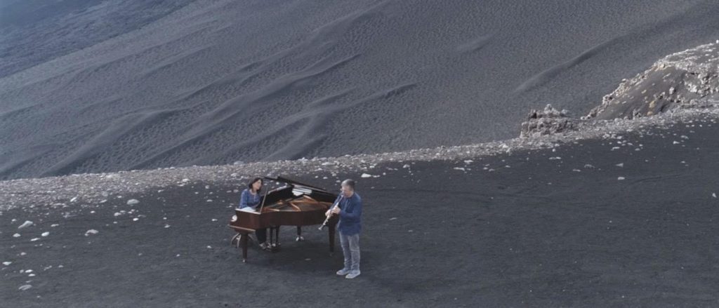 Etna, 2850 metri. Ecco “Negheb”, un pianoforte e un clarinetto per un sublime abbraccio tra musica e natura. Mount Etna, 2850 meters. Here is “Negheb “, a piano and a clarinet for a sublime embrace between music and nature